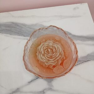 Vela con rosa en pozuelo de vidrio